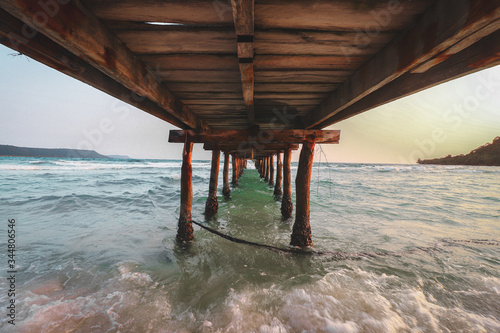 Cinematic summer scenery of waves under a wooden pier in Sok San Beach Koh Rong Island in Cambodia