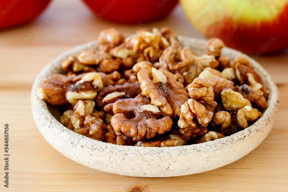 Bowl of walnuts and apples in the background. Bowl of walnuts and apples in the background.