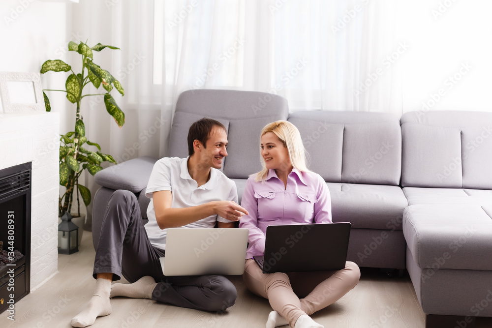 Happy young casual couple sitting working together at home office, smiling. Happy young casual couple sitting working together at home office, smiling.