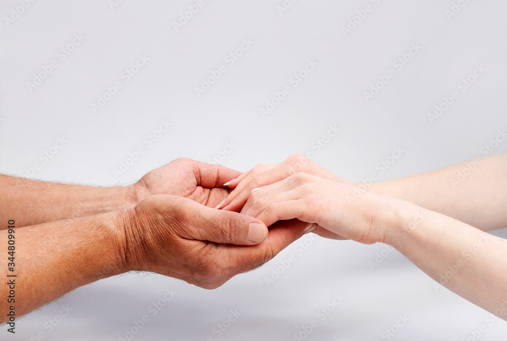 The man is holding the woman's hands.