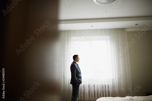 Grooms morning preparation. Handsome man getting dressed and preparing for the wedding