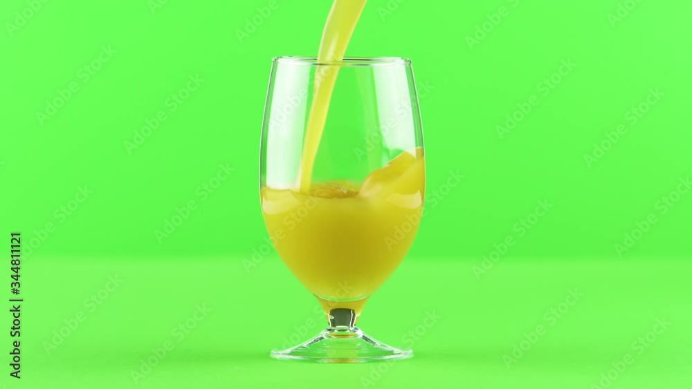 Juice pouring into goblet isolated on light green background , vitamin and mineral juice healthy lifestyle Juice pouring into goblet isolated on light green background , vitamin and mineral juice healthy lifestyle