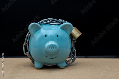 blue Piggy bank locked, chained with black background, Protect savings, Protect capital, Protect retirement fund concept