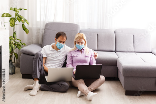 A young family works from home using computers. Couple working remotely online while on quarantine. Stay at home concept. Corona virus covid-19 pandemic outbreak. Freelance work