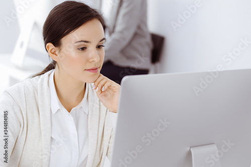 Casual dressed business woman working with computer in office. Lawyer or accountant at work