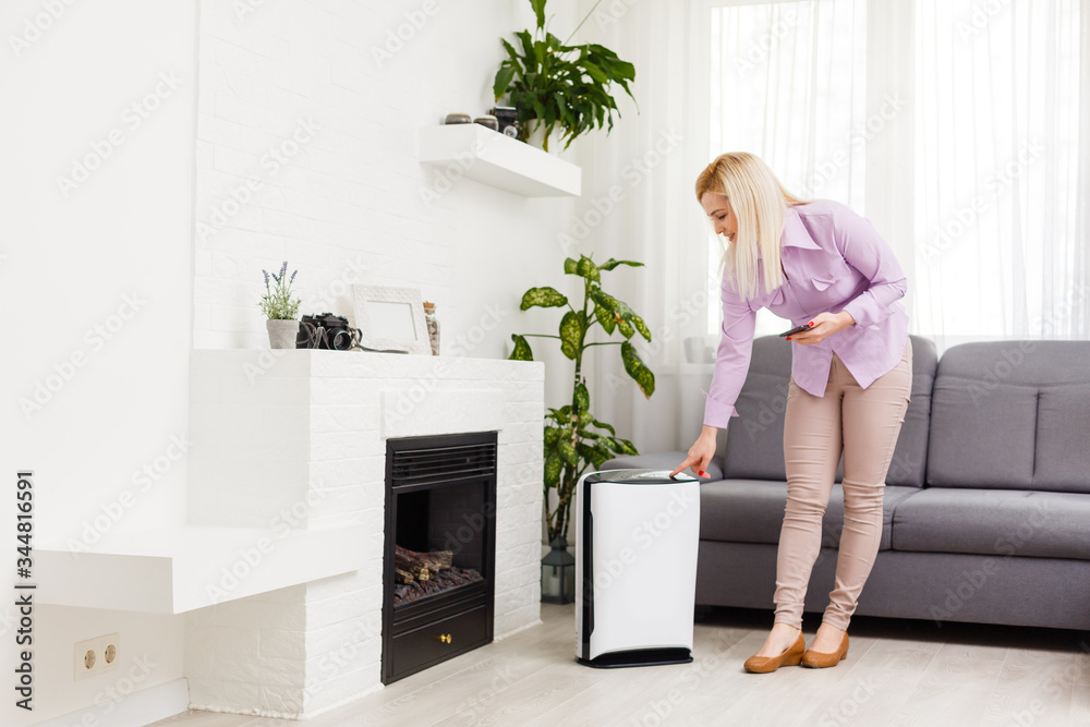 Air purifier , Business woman working with laptop use phone with filter for clean room in a living room Air purifier , Business woman working with laptop use phone with filter for clean room in a living room