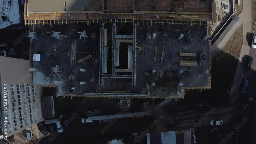 Aerial shooting of a high-rise building under an office at a construction site, Kharkov, Ukraine. Top view of a crane and workers building a house for living. The construction of a new modern house. Aerial shooting of a high-rise building under an office at a construction site, Kharkov, Ukraine. Top view of a crane and workers building a house for living. The construction of a new modern house.