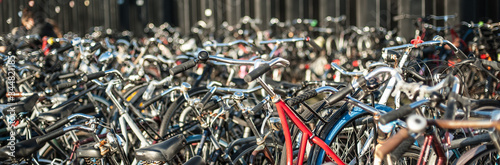 Group of a lot of old holland vintage classic bicycles row parked at parking station in public. Cityscape view. Dutch lifestyle