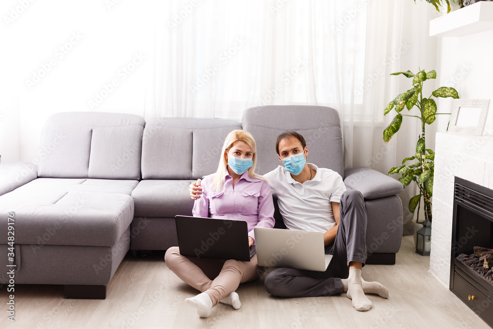A young family works from home using computers. Couple working remotely online while on quarantine. Stay at home concept. Corona virus covid-19 pandemic outbreak. Freelance work