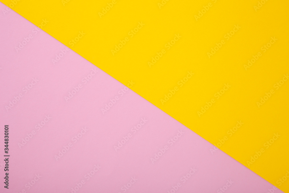 Pink and yellow paper as background. Two colored pastel paper texture, top view with place for text