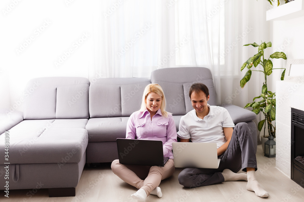 Happy young casual couple sitting working together at home office, smiling. Happy young casual couple sitting working together at home office, smiling.