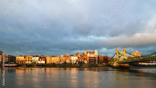 A west London timelapse scene of the north bank of the River Thames including Hammersmith Bridge and attractive riverside buildings