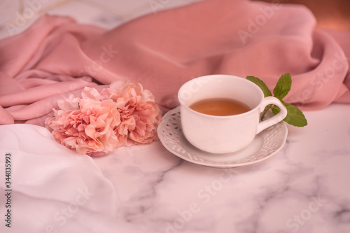 Pausa relax con libro, tè caldo e peonie rosa
