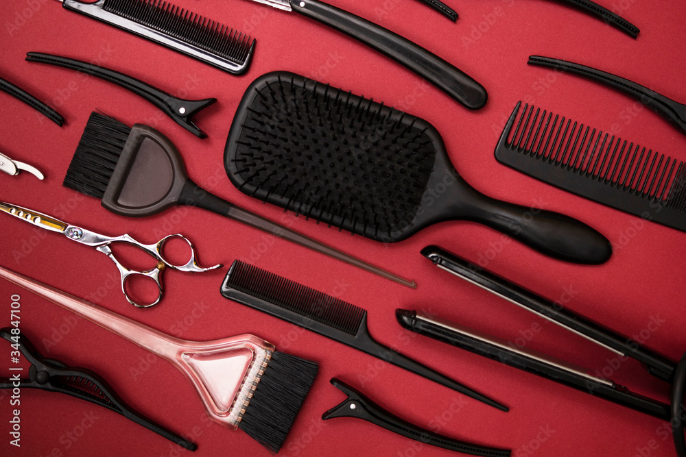 Fototapeta premium combs and hairdresser tools on red background top view