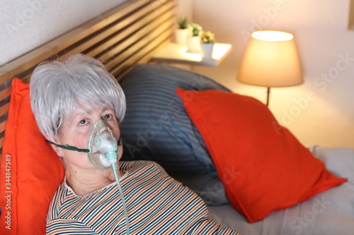 Senior woman using oxygen mask 