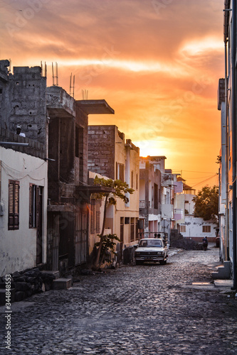 Fototapeta Naklejka Na Ścianę i Meble -  Sunset among the buildings in the streets of the small village of Vila do Maio