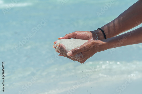 Hand holding white beach sand. Famous white silica sand. Whitehaven beach, Whitsundays. Turquoise ocean, white sand. Travel, holiday, vacation, paradise. Shot in Hill Inlet, Queenstown, Australia.