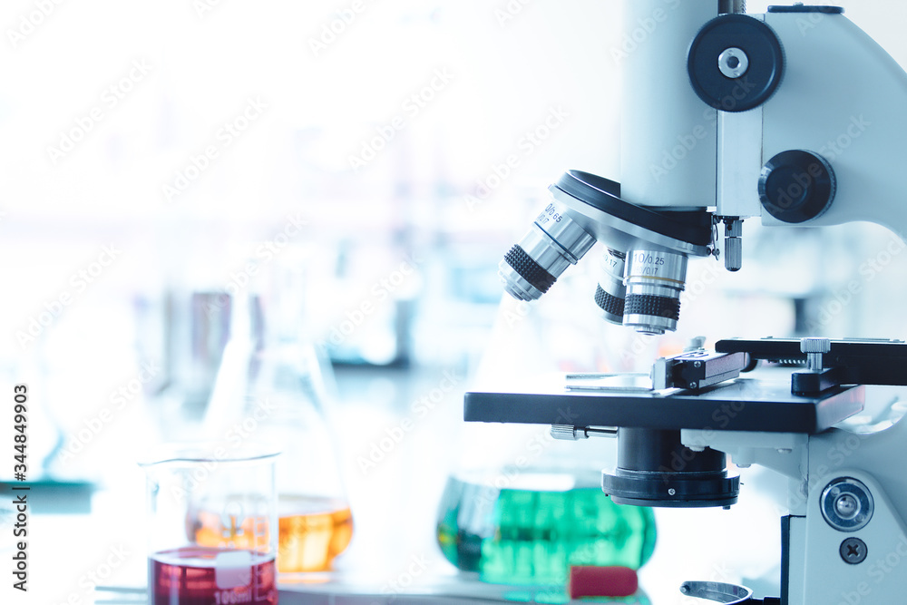 A laboratory microscope for scientific research in laboratory room with different laboratory glasswar background. Free copy space for text or design. A laboratory microscope for scientific research in laboratory room with different laboratory glasswar background. Free copy space for text or design.