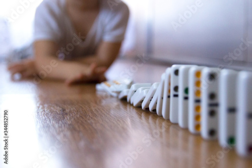 Kid lying, playing domino in living room.