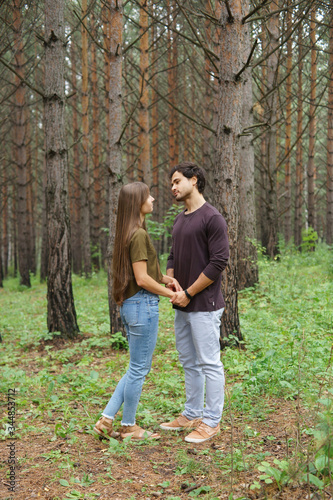Portrait of young couple - man and woman in casual clothes in the wood in summer