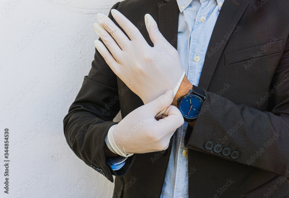 Business man puts on gloves. Coronavirus : Business man wears protective gloves. Business man puts on gloves. Coronavirus : Business man wears protective gloves.