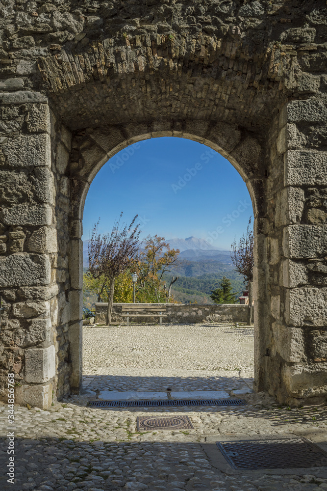 Breath-taking view of the mountains framed by the historic gate of the ancient village of Collalto Sabino near Rieti, Lazio, Italy