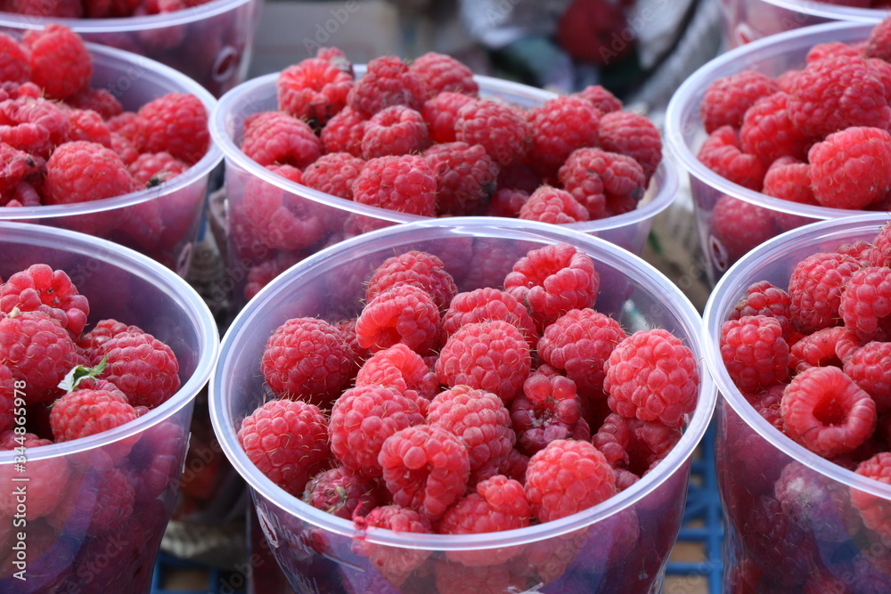 large and ripe raspberries in plastic cups large and ripe raspberries in plastic cups