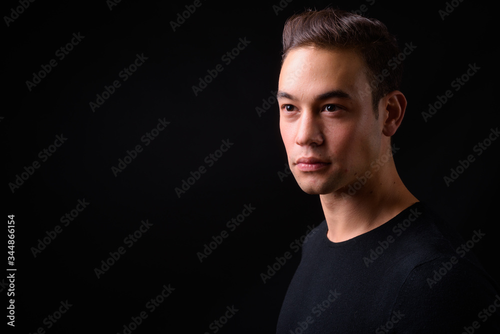 Naklejka premium Młody przystojny wieloetniczny mężczyzna na czarnym tle