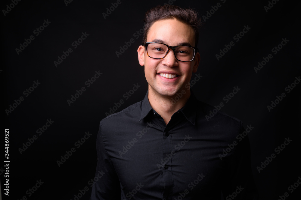Obraz premium Young handsome multi ethnic businessman against black background