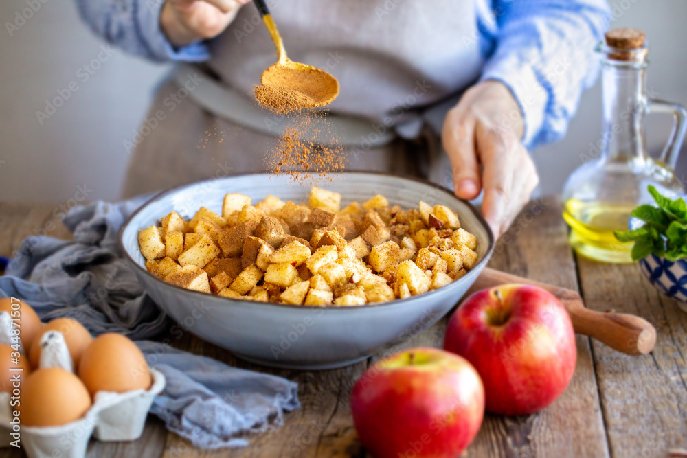 Add a spoonful of cinnamon to the filling of the cake. Cinnamon for apple strudel. Sliced apples with raisins and cinnamon. Cooking a pie. Apple pie. Cinnamon flies in a bowl with apples
Add a spoonful of cinnamon to the filling of the cake. Cinnamon for apple strudel. Sliced apples with raisins and cinnamon. Cooking a pie. Apple pie. Cinnamon flies in a bowl with apples