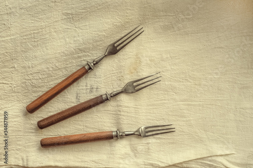 Three old forks on an old yellow cloth