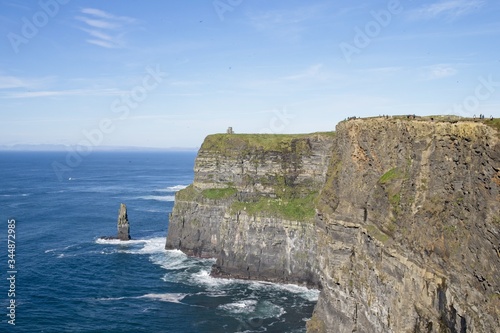 Mesmerizing scene of the ocean waves crashing into cliffs of Moher located in Ireland