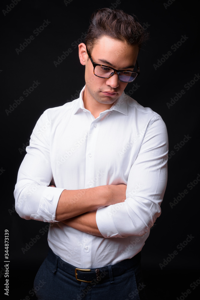 Young handsome multi ethnic businessman against black background