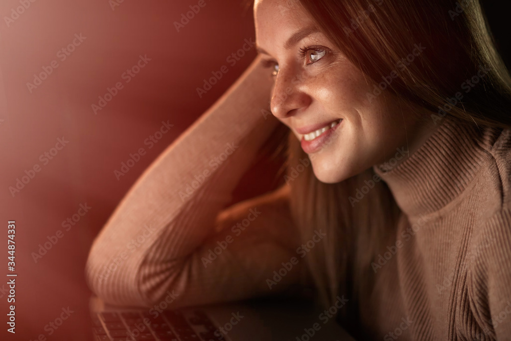 Happy woman checking laptop content sitting at home in the night Happy woman checking laptop content sitting at home in the night