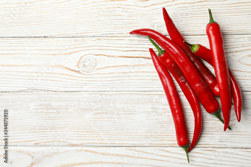 Chilli peppers on wooden background, top view
