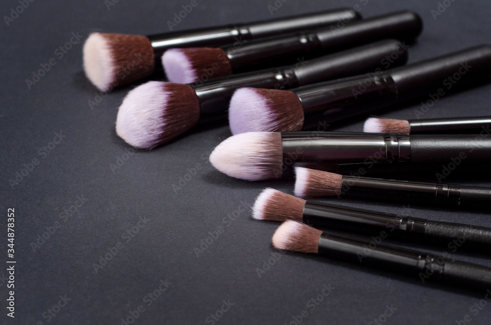 Fototapeta Set of flat top view of various professional female cosmetics brushes for makeup and eyelash brush isolated on black background, Cosmetics concept, Make up concept, Copy space image for your text.