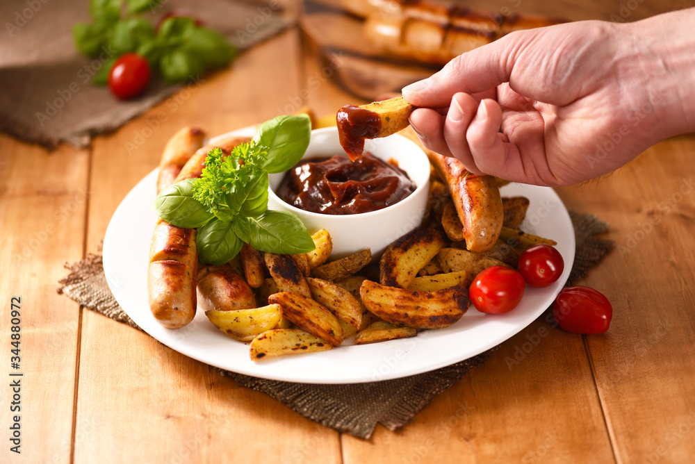 Fried fries with sausages and ketchup. Full, delicious food and not healthy. Fried fries with sausages and ketchup. Full, delicious food and not healthy.