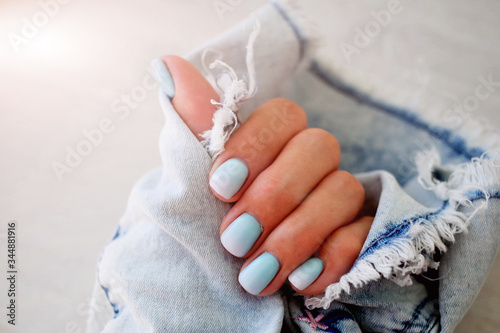 Female hands with a beautiful manicure on a jeans background. photo