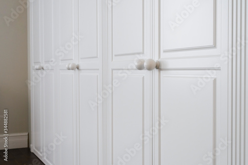 White cabinet doors with brown floor handles