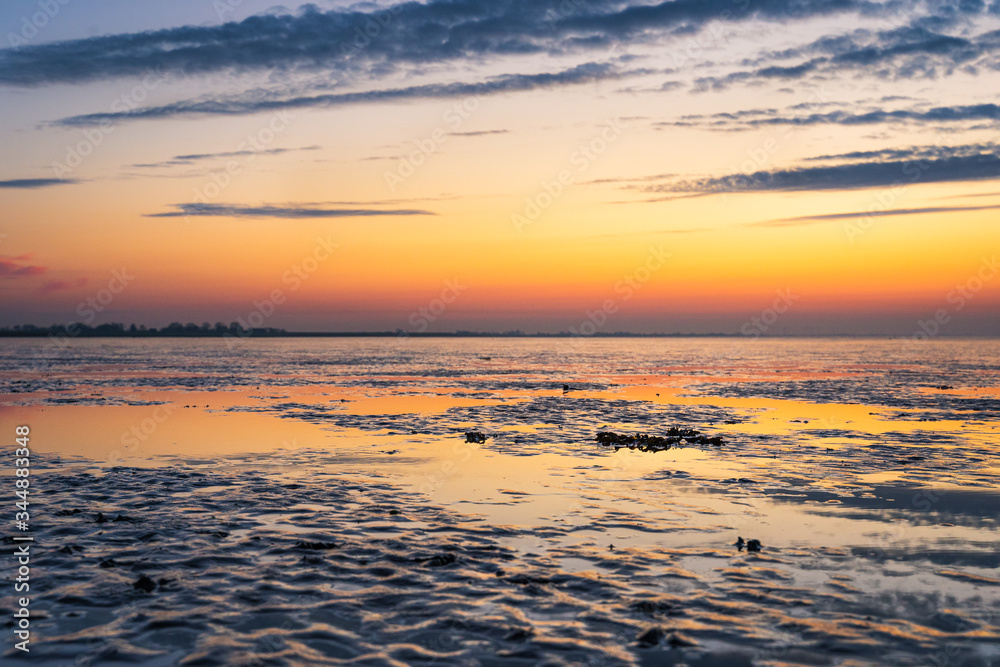 Abenddämmerung mit Spiegelungen am norddeutschen Wattenmeer.