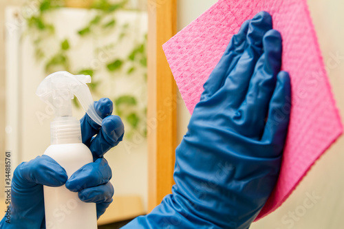 A human hands in a protective gloves disinfect surface using disinfectant and cleaning cloth for viruses prevention