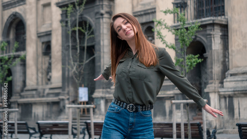 Close up portrait of a beautiful smiling girl with brown hair. Urban city background © Rudchyks