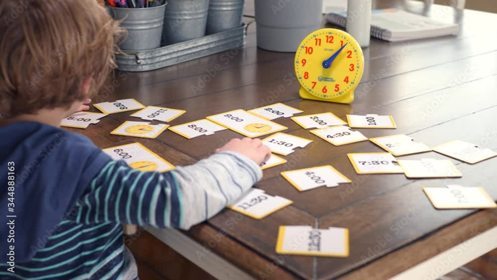 Little Boy Looking At Time Illustrations And Studying Clock. Blond boy is sitting at home during covid-19 pandemia and he is learning how to tell time.