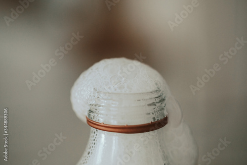 Milk foam on top of a glass bottle 