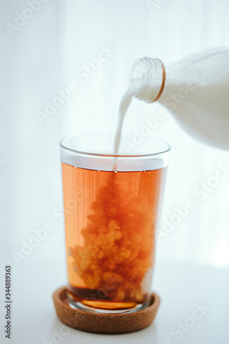 pouring milk into a black tea glass