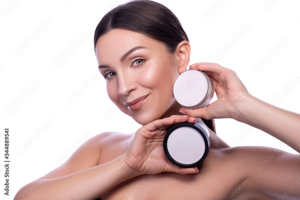 Cute smiling brunette adult girl with mock up botles in her hands. Beauty headshot isolated on white. Space for text/logo Cute smiling brunette adult girl with mock up botles in her hands. Beauty headshot isolated on white. Space for text/logo