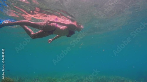 Low angle view of woman snorkeling underwater, she is swimming in ocean - Lombok, Bali photo