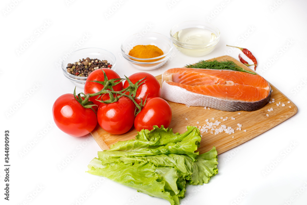 salmon steak with vegetables and spices on a wooden background. The concept of cooking. Grocery background.