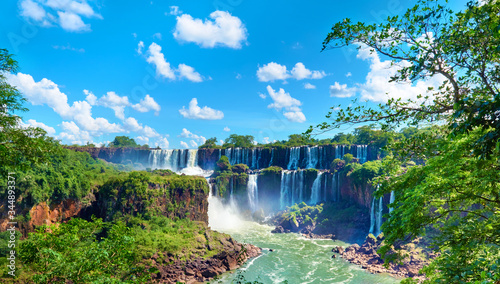 Fototapeta Naklejka Na Ścianę i Meble -  Iguazu waterfalls in Argentina, powerful water streams creating mist over Iguazu river. Panoramic image of waterfalls and sub-tropical rain forest in the river valley.