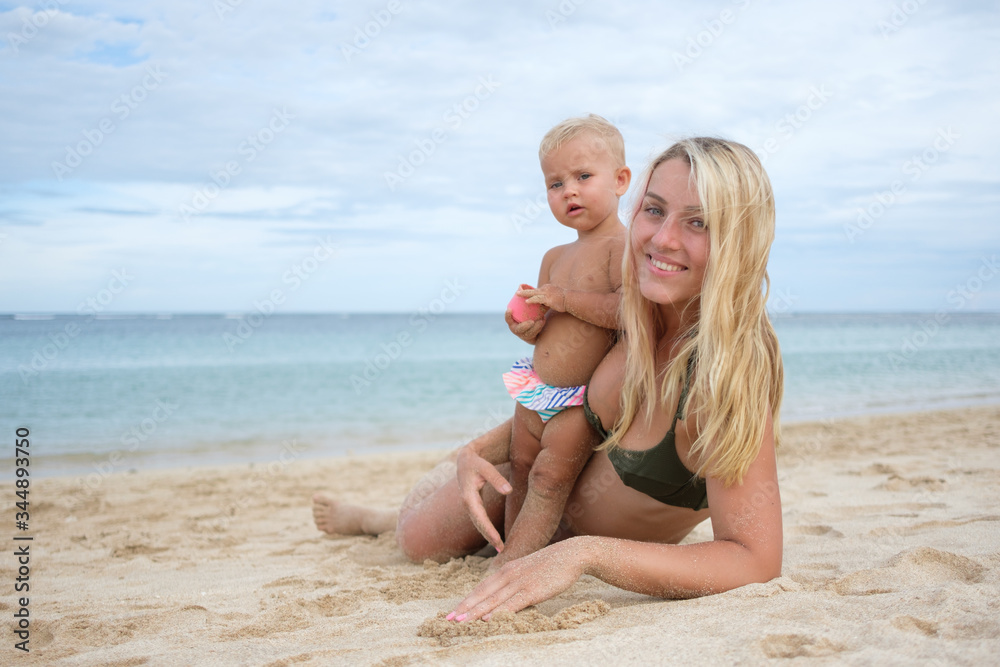 Beautiful portrait of mother and daughter on the sea and beach background.